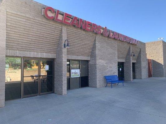 Front of business. Left is dry cleaning and wash and fold. Right of bench is entrance to laundromat.