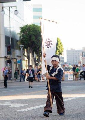 Young Shinkendo Boston pracitioner carries a flag