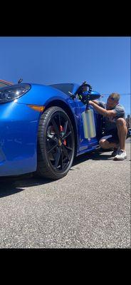 Using the Paintless dent repair method to remove a ding from a car.