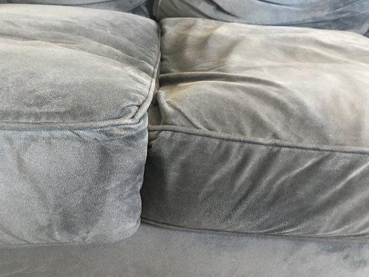 There are dents in the couch where the cushions have caved.