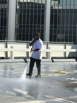 Pressure washing roof top of parking lot in Beverly Hills