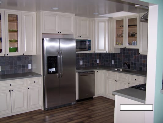 Creme cabinets, new appliances, laminate flooring, lights, paint, slate 4 x 4 splash tile and Quartz countertops.