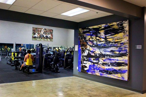 Some art with a view of the weight room from the lounge.