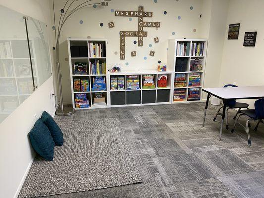 Fun and engaging therapy room with floor space, child-sized work table, and parent seating