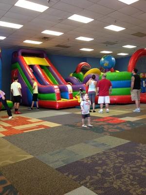 staff members standing around talking with their backs turned to the children on the slides