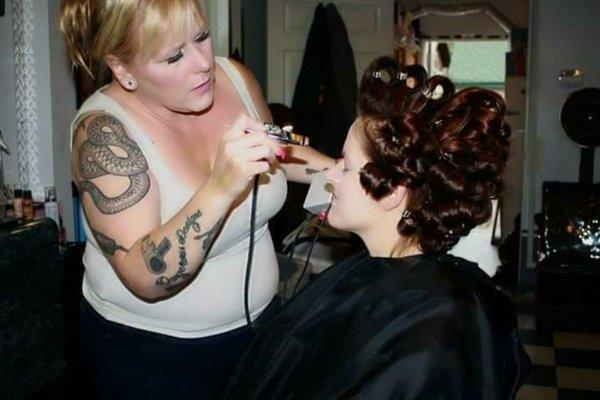 Air brushing makeup on a bride.