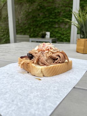 Smoked pulled pork sandwich topped with coleslaw