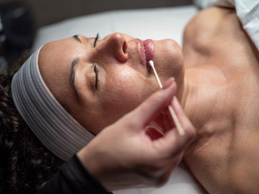 Relax while enjoying a spa facial with facial enhancements like lip treatments