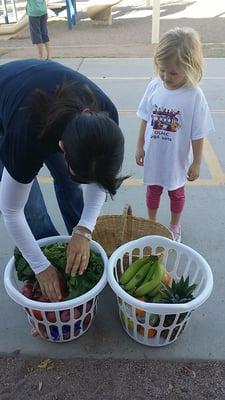 Participants load the fruits and veggies that have been distributed into their own basket, bag, or box.