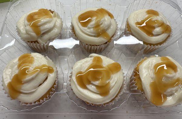 Caramel Filled Vanilla Cupcakes with vanilla frosting and a caramel drizzle.