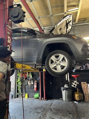 Jeep on a lift to get an oil change.