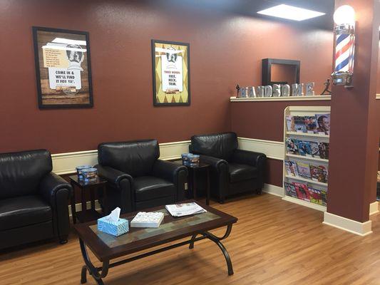 Leather chairs, large screen TV, magazines and newspapers