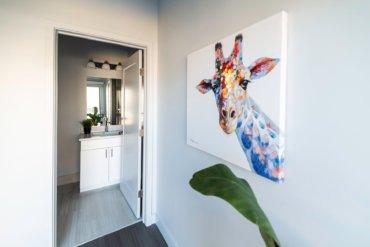 First-floor half bath in our 2-bedroom townhome; adjacent to a modern kitchen and balcony with sliding glass doors.