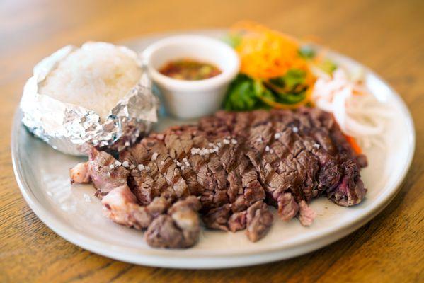 SUA RONG HAI - A famous Thai style charbroiled rib-eye steak served with spicy and sour rice powdered dipping sauce and sticky rice.