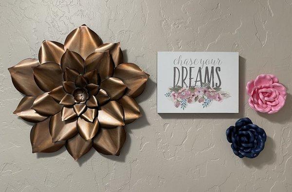 Bronze flower beside Chase Your Dreams picture with a pink and blue flower accent.