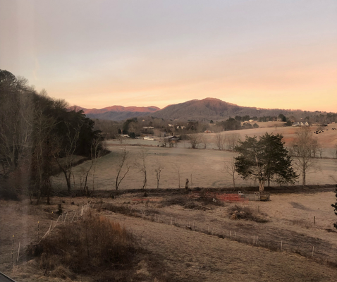 First glimpse of sunrise on the mountain tops! Taken from inside the house.