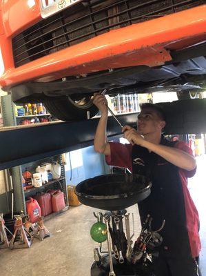 Steven performing a routine oil change