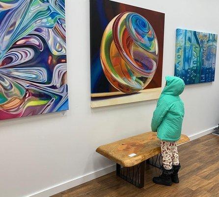 A young art connoisseur admiring a painting by Kristen Reitz-Green.