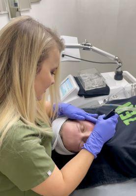 McKenzie, Licensed Aesthetician, performing a Customized Facial