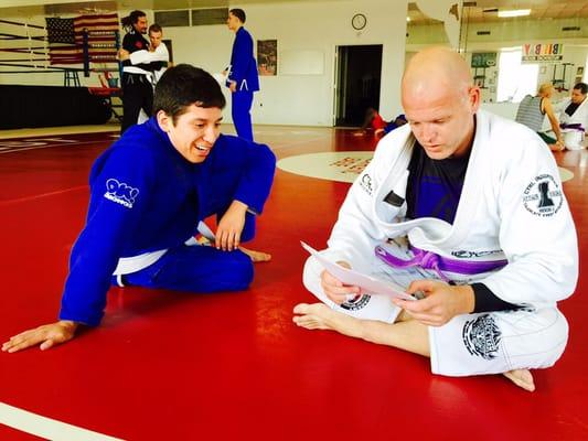 Rich Thomas helping a student prepare for his Blue Belt test