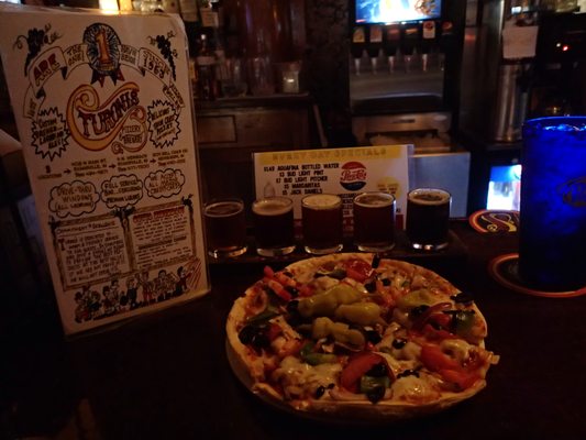 Turoni's small house special pizza with a flight of their home-made brews