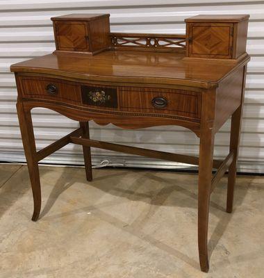 photo on Chairish website. Desk shows both drawer pulls intact and no damage to the front or sides.  Top looks beautiful and glossy.