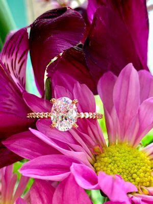 Oval shaped diamond engagement ring with diamond accented band from Thurber Jewelers.