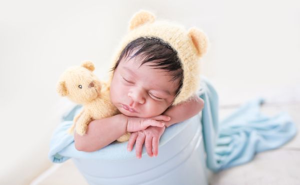 newborn snuggling one of our bear lovies