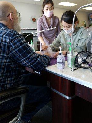 A man getting a hot wax treatment on his hands. Men come here too!