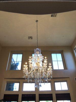 Brilliant crystal chandelier dressed, assembled, and installed on 20 FT ceiling