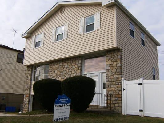 Removed old wood siding and installed new vinyl siding in Maple with white shutters and all new vinyl hung windows on house