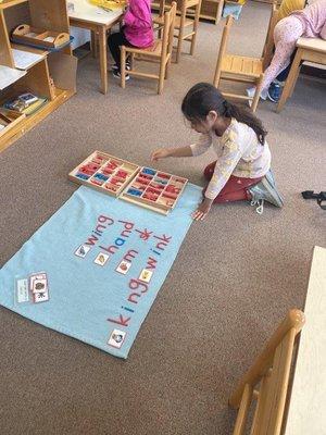 Child works with the moveable alphabet