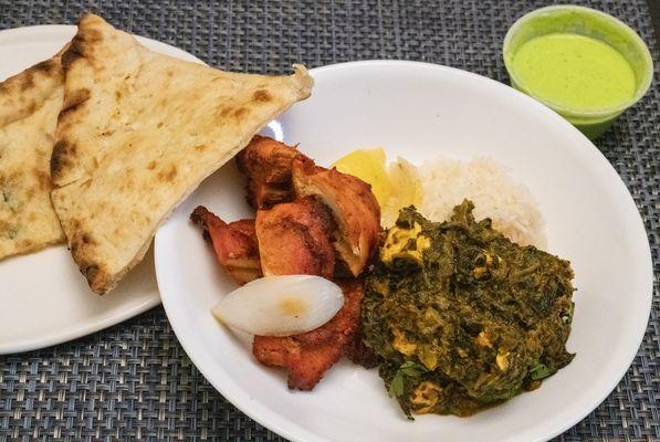 Partial orders of garlic naan, chicken tikka, palak paneer, rice, raita.