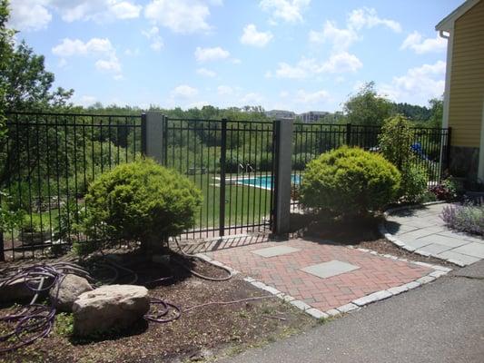 Black aluminum fence with custom granite posts.