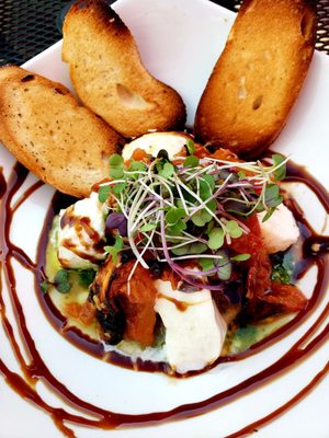 Delicious burrata & tomatoe salad with fresh arugula, over ratatouille with balsamic drizzle & truffle oil