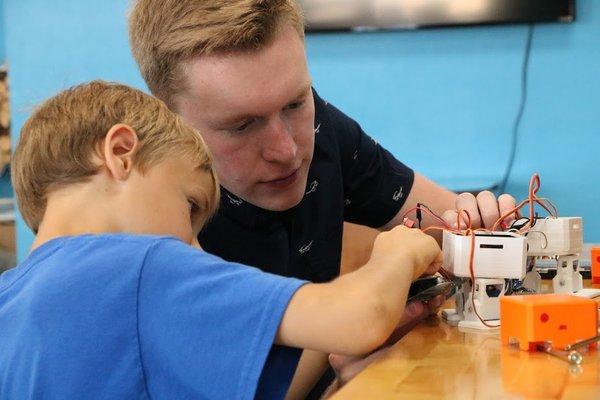 Intern Christian Scarlett works to help a student build Otto The Robot.