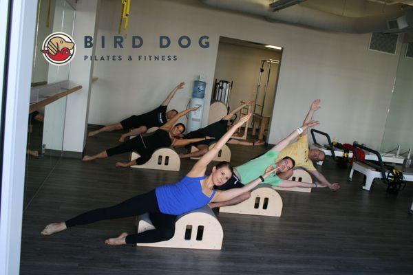 Total Body Pilates is a mat-based class that uses the Spine Corrector and other Pilates props.