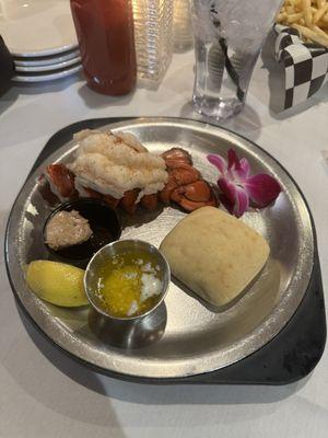 2024 Valentine's dinner, lobster tail, and a freshly baked roll.