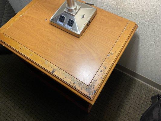 Nightstand with lots of burn marks from cigarettes or joints/blunts