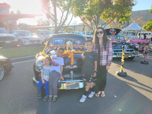 My wife and kids in front of her dad's Mercury ofrenda