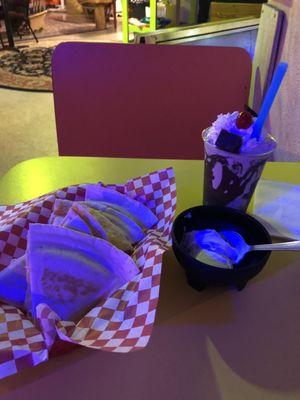 Chicken quesadilla with a side of sour cream and a cosmic brownie shake