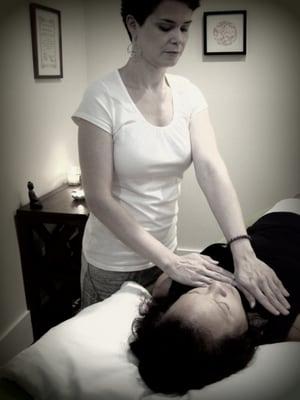 Dana giving a Reiki session in her treatment room