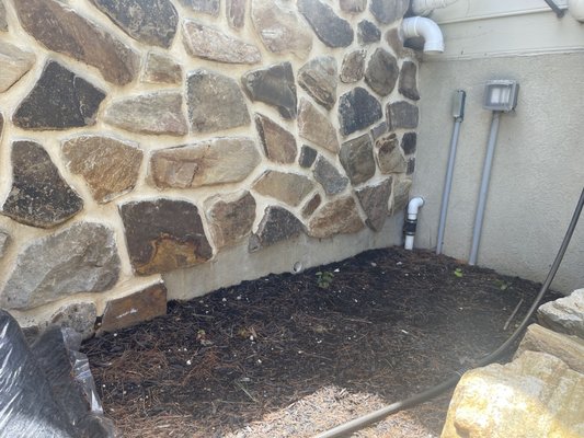 Stone veneer not applied all the way to the bottom of the concrete wall.  Leaves an unsightly view of the concrete wall.