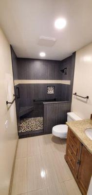 Beautiful walk inn shower with a half wall and floating bench.