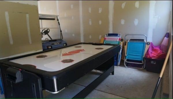 Garage with golf cart and reversible pool/air hockey table.