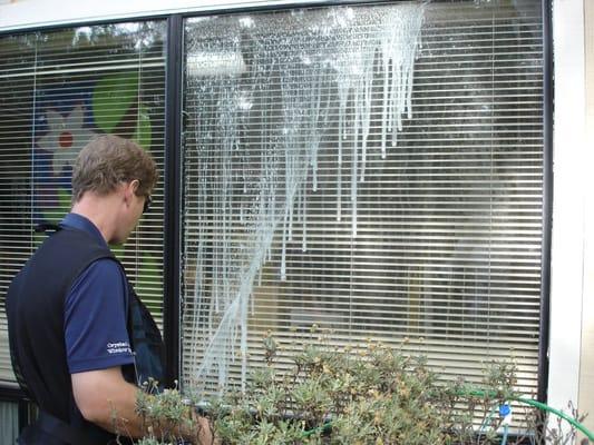 Injecting cleaning solution in a failed double pane unit.  Call 831-359-4400 for this unique service