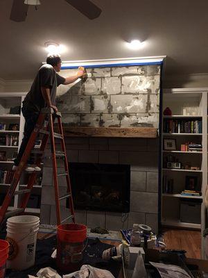 Hanging a new mantel and refacing the wall around the fireplace.