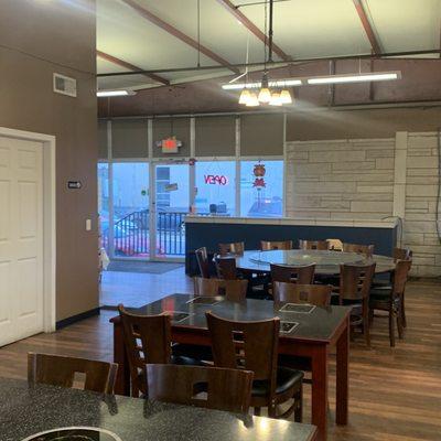 Inside of the restaurant. Tables have heating plates and there's a large table with a lazy Susan for groups.