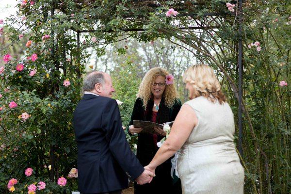 The bride dreamed of a wedding under a rose arbor. Reverend Kathleen found the perfect place.