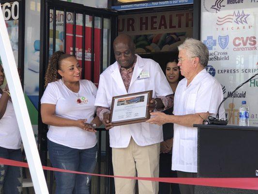 Councilman Bob Coffin presenting a citation from the city of Las Vegas to Belmont Pharmacy